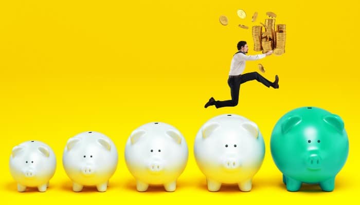 Man Holding Money Jumping Piggy Banks